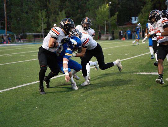 Riley McCullar and Alex Juliot team up to tackle South Tahoe’s Conner Hennessee during the  game last Friday at South Tahoe. Photo by Leanne Cruz, Cruz Down Memory Lane Photography,  LLC