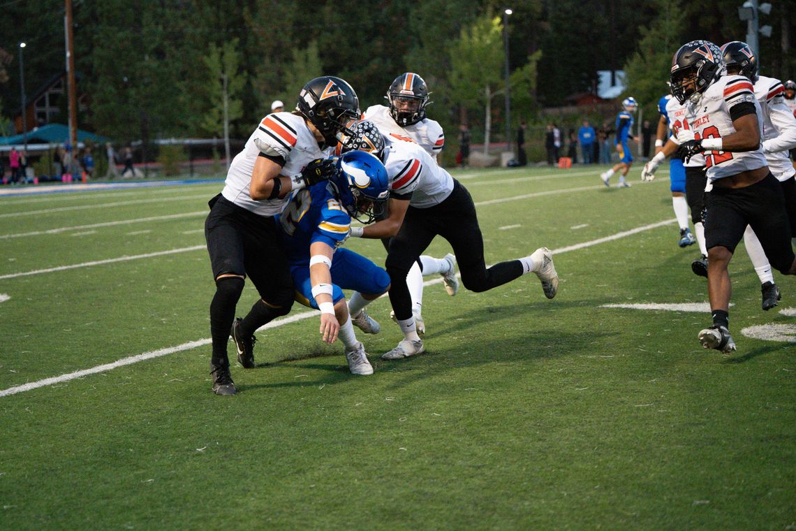 Riley McCullar and Alex Juliot team up to tackle South Tahoe’s Conner Hennessee during the  game last Friday at South Tahoe. Photo by Leanne Cruz, Cruz Down Memory Lane Photography,  LLC